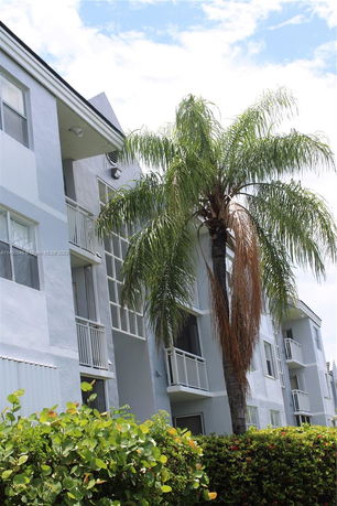 Front view of a multi-story residential building with balconies.