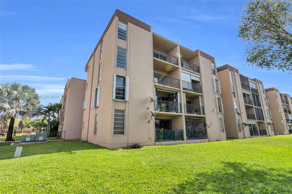Front view of a multi-story apartment building with balconies.