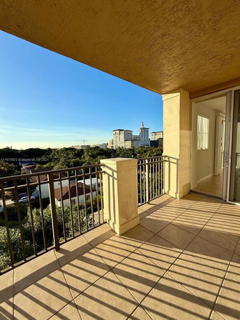 View from a balcony showing buildings and greenery.