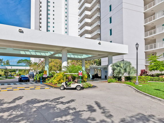 Front view of a tall residential building with a covered entrance area.
