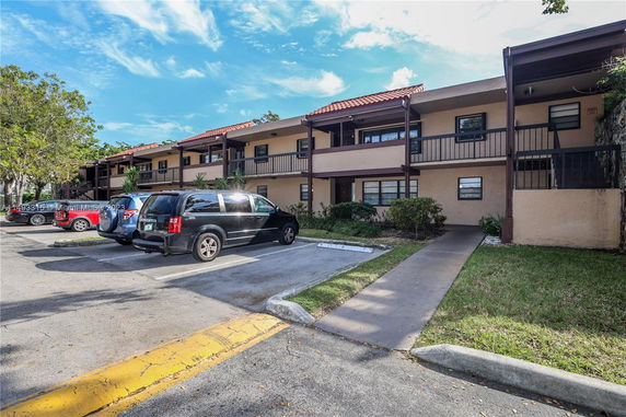 Outdoor parking area in front of a two-story building.