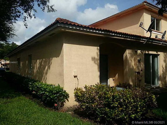 Front view of a beige single-story house with tile roofing.