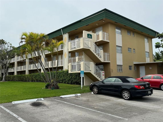 Front view of a three-story apartment building with multiple balconies.