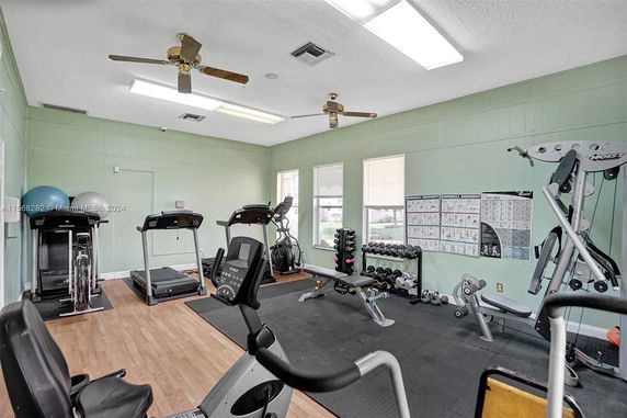Indoor gym area with exercise equipment including treadmills, bikes, and weights.