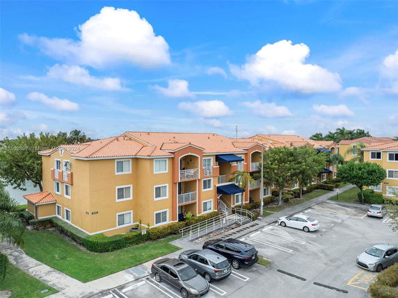 Front view of an apartment building with multiple levels and parking area.