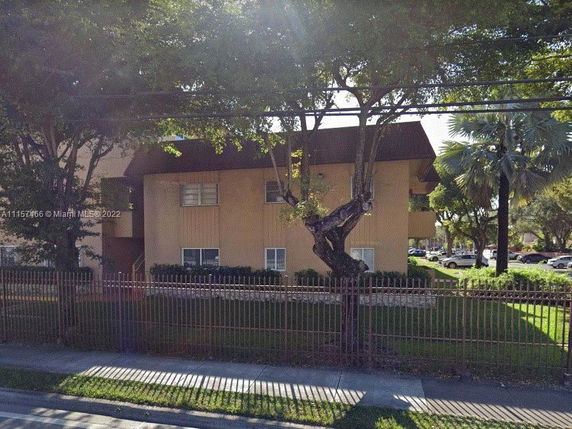 Front view of a two-story building with a fenced yard.