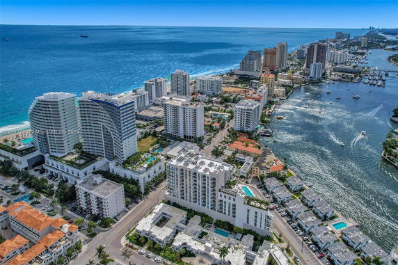 Aerial view of a coastal city with high-rise buildings next to a beach and waterway.