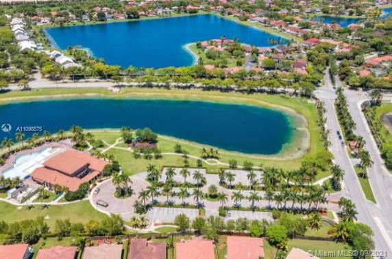 Panoramic view of a residential neighborhood with a large lake and houses.