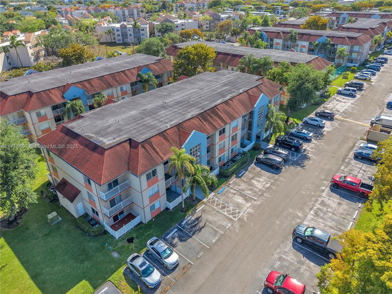 Aerial view of residential apartment buildings with parking area.