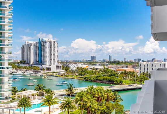 View of waterfront buildings and a marina with boats.