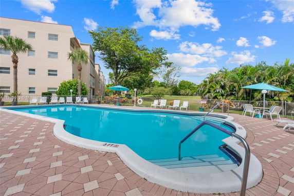 Outdoor swimming pool area with surrounding deck chairs and umbrellas.