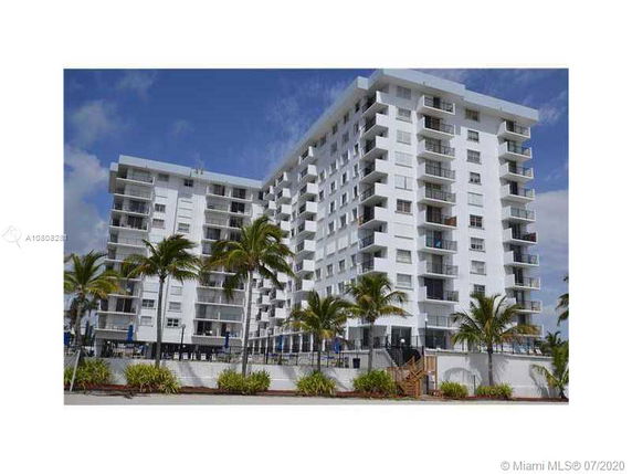 Front view of a multi-story white apartment building.