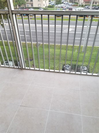 View from a tiled balcony showing a road and adjacent areas.