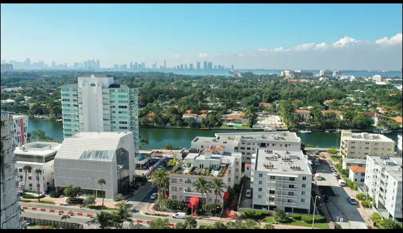 Wide-angle view of a cityscape with buildings and greenery.