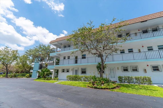 Front view of a three-story residential building with balconies.