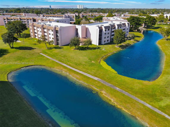 Aerial view of multiple residential buildings near a curving water body.