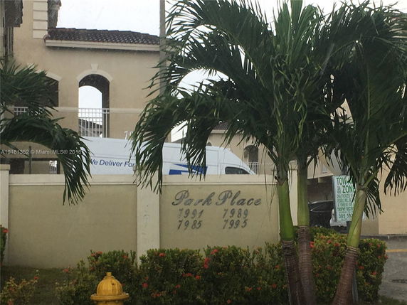 Front view of a multi-story building with arch windows and a tiled roof.