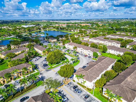 Aerial view of residential apartment complexes with parking and greenery.