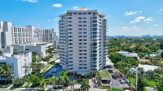 Front view of a tall residential building with multiple balconies.
