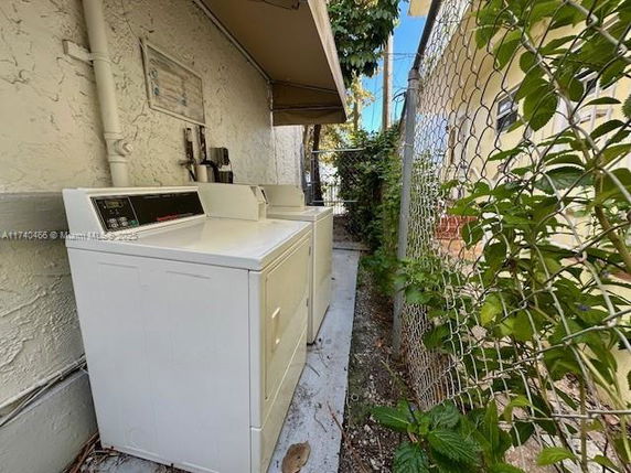 Outdoor laundry area with two machines next to a building.