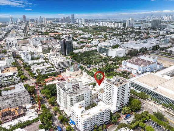 Aerial view of a cityscape with high-rise buildings and a marked location.