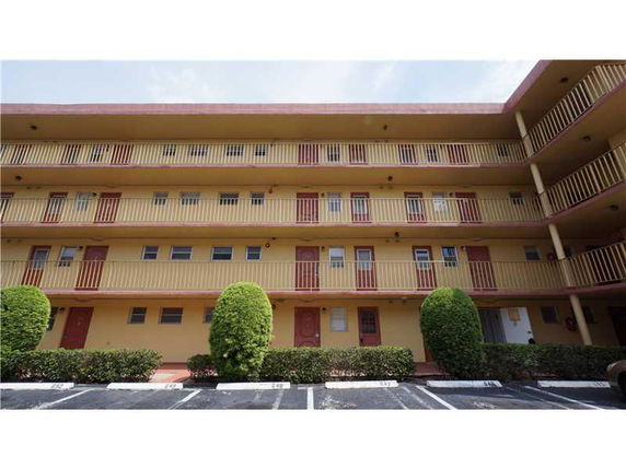 Front view of a multi-story apartment building with balconies.