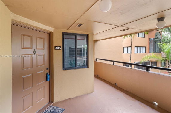 Exterior view of a building corridor with a door marked 305 and windows.