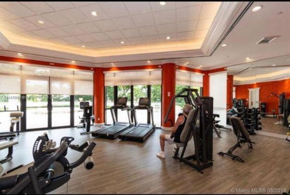 Indoor view of a gym area with exercise equipment and large windows.