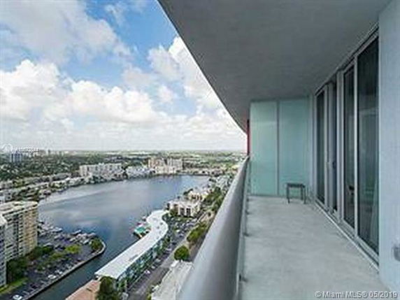 Panoramic view from a high-rise balcony overlooking a body of water and surrounding buildings.