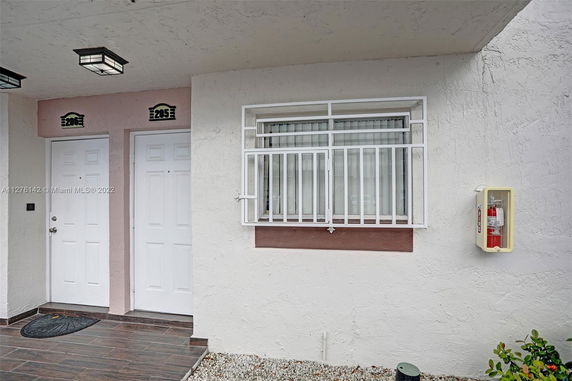 Front view of a building with two doors and a window with metal bars.
