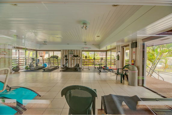 Indoor gym area with exercise equipment and large windows.