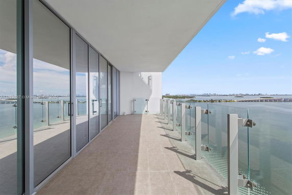 Balcony view of a waterfront area with city skyline in the distance