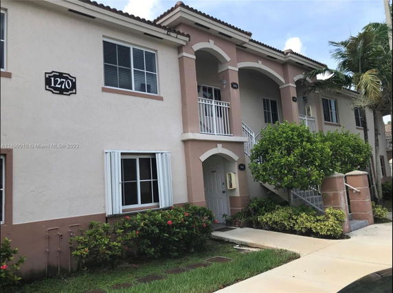 Front view of a two-story residential building with arched balconies.