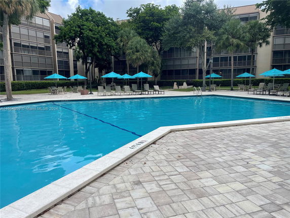 Swimming pool area with multi-story residential buildings in the background.