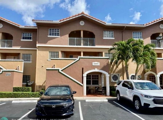 Front view of a three-story residential building with parking spaces.