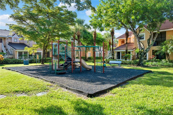 Outdoor playground with slides and climbing structures in a residential area.