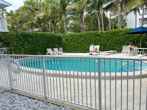 Outdoor swimming pool area with lounge chairs and umbrellas.