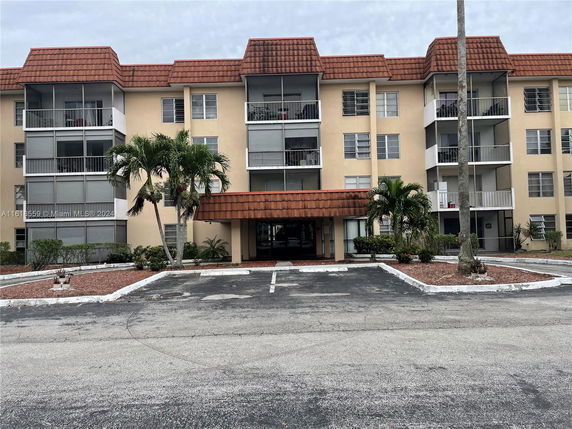 Front view of a multi-story apartment building with balconies.