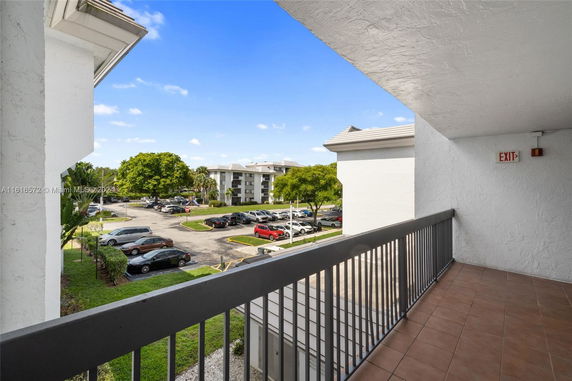 View of a parking area and surrounding buildings from a balcony.