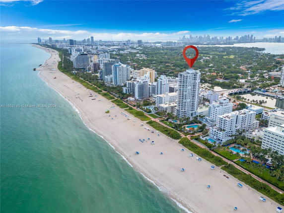 Aerial view of a beachfront area with high-rise buildings along the coastline.