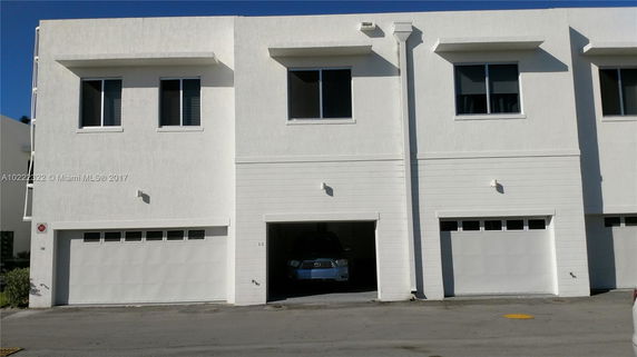Front view of a modern two-story building with multiple garages.