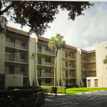 Front view of a multi-story apartment building with balconies.
