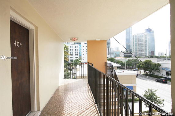 View from a building hallway showing city skyline and street below.