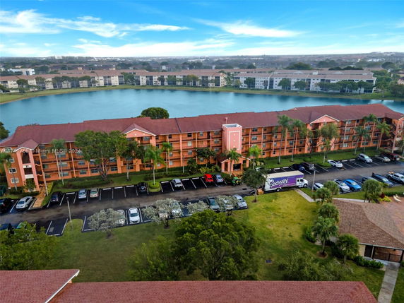 Aerial view of an apartment complex with a lake in the background.