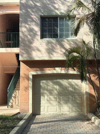 Front view of a house with a garage and a staircase leading to the upper level.