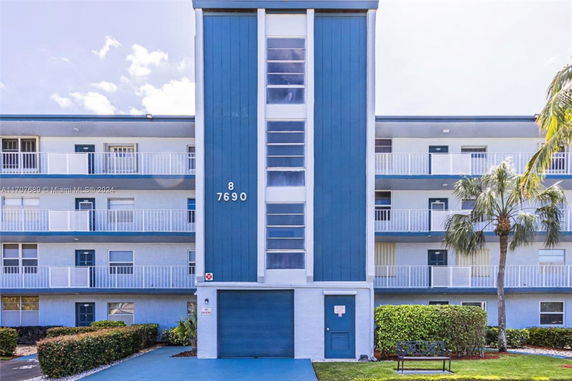 Front view of a four-story building with blue and white exterior.