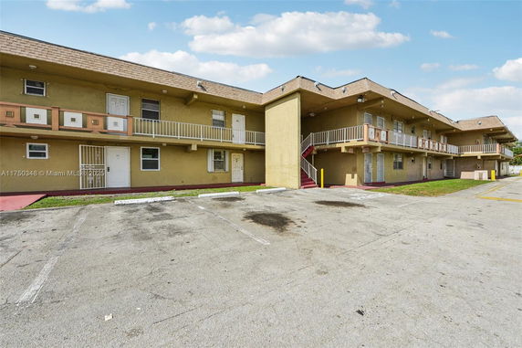 Front view of a two-story apartment building with exterior staircases and second-floor balconies.