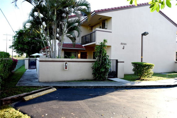 Front view of a residential building with a gated entrance and balcony.