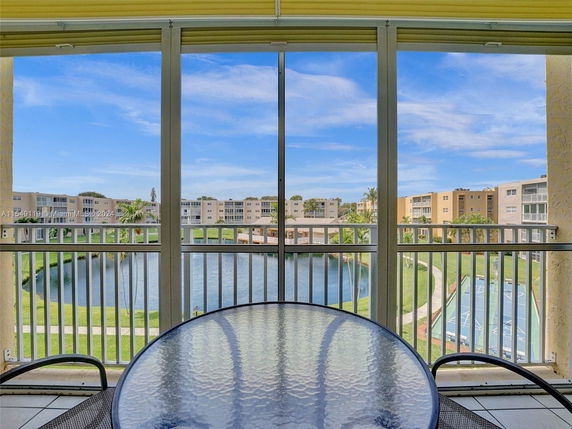 View of multiple residential buildings surrounding a pond, seen from a balcony.