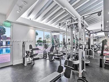 Gym area with various exercise equipment and large windows.